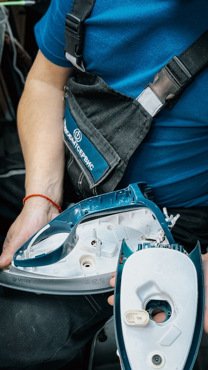 who-we-are Close-up of technician disassembling an iron for repair.